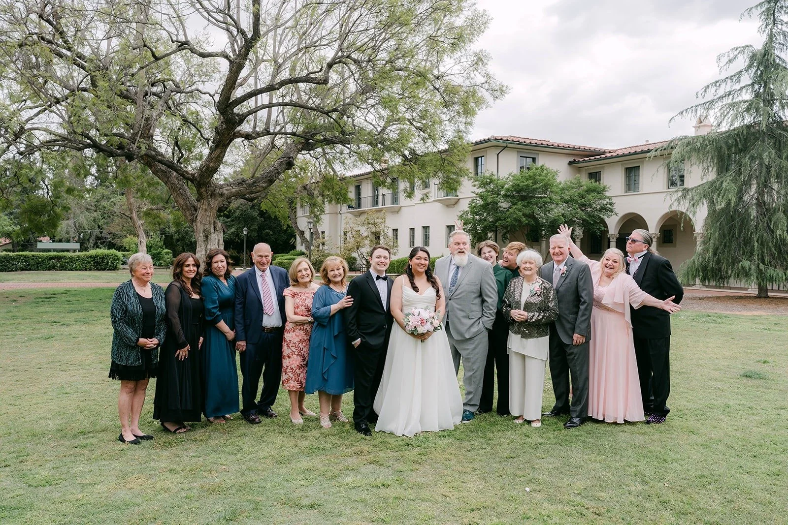 Saira and Matthew with their family and friends on the lawn in front of The Athenaeum