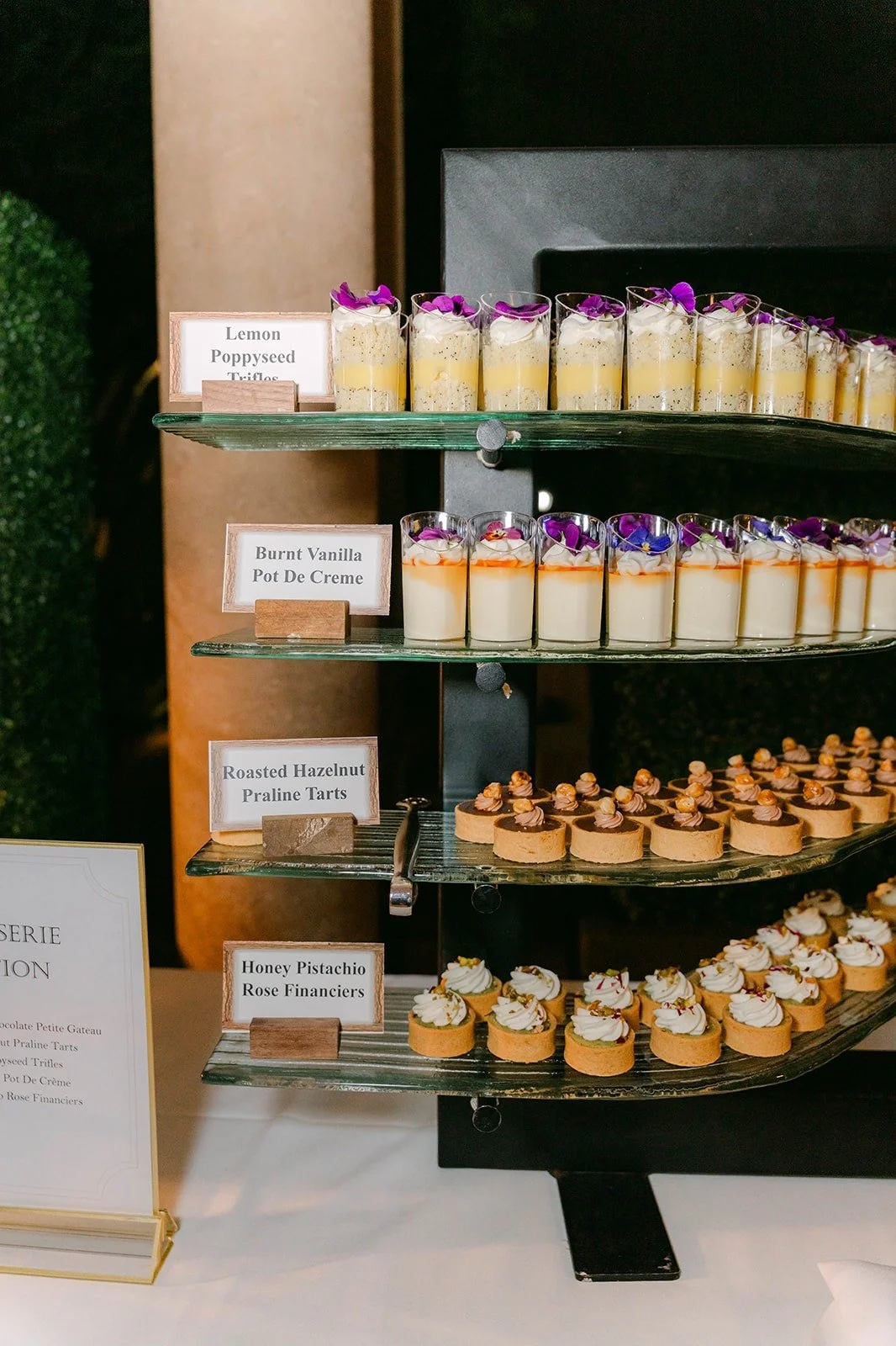 A dessert stand stacked with mousse cups and small pastries, photographed by One and Only Production