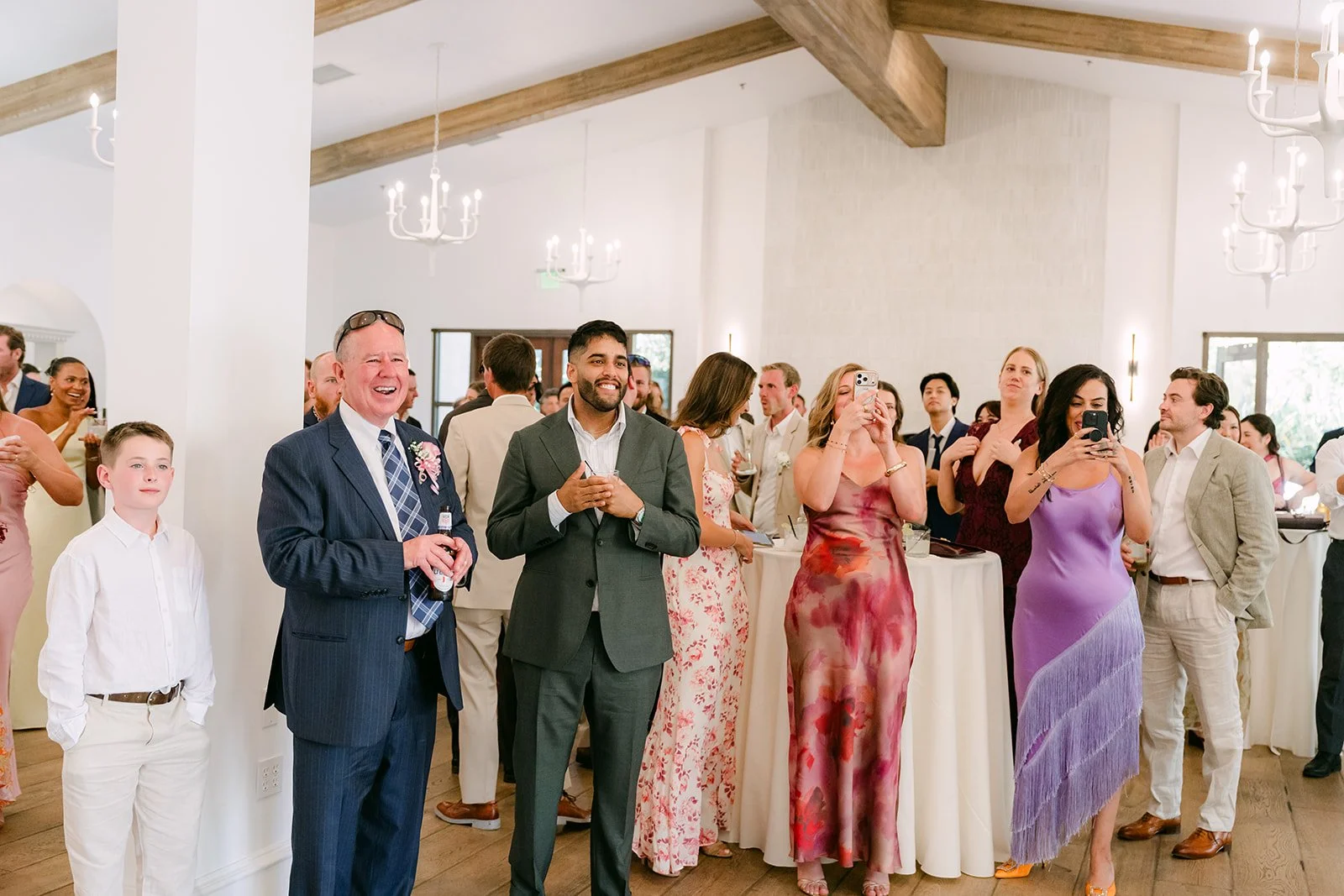 Guests watching and laughing indoors during cocktail hour