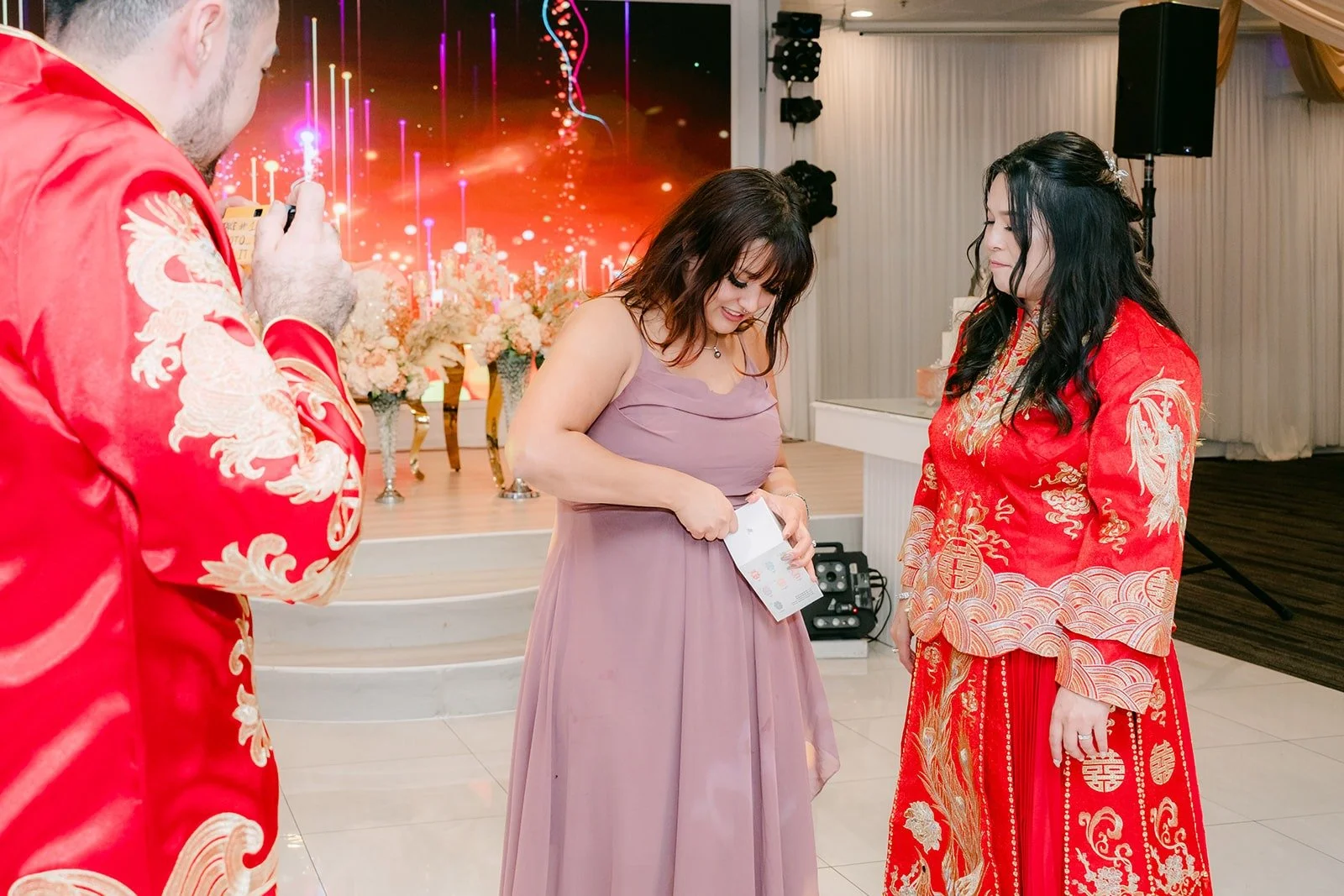 A guest catching the bouquet as Amy cheers
