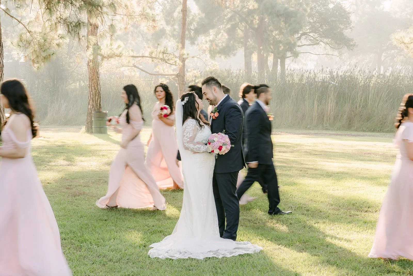 Amy and James walking with their wedding party in the distance