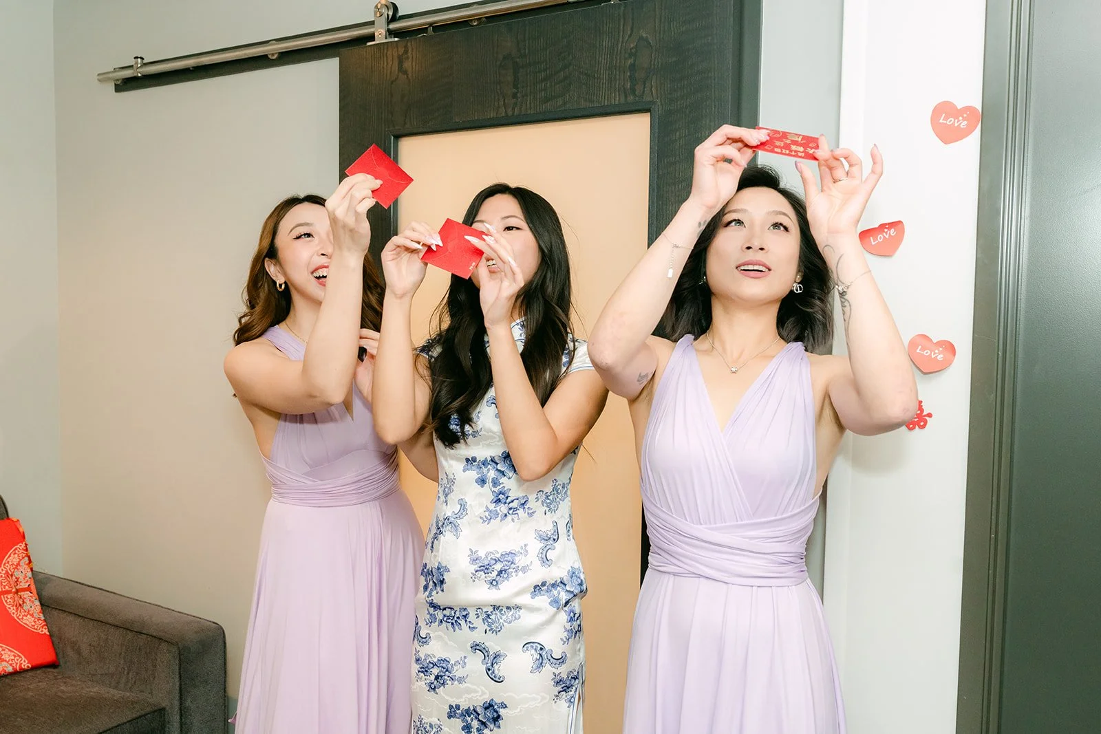 Bridesmaids showing off the red envelopes they collected from the groomsmen.