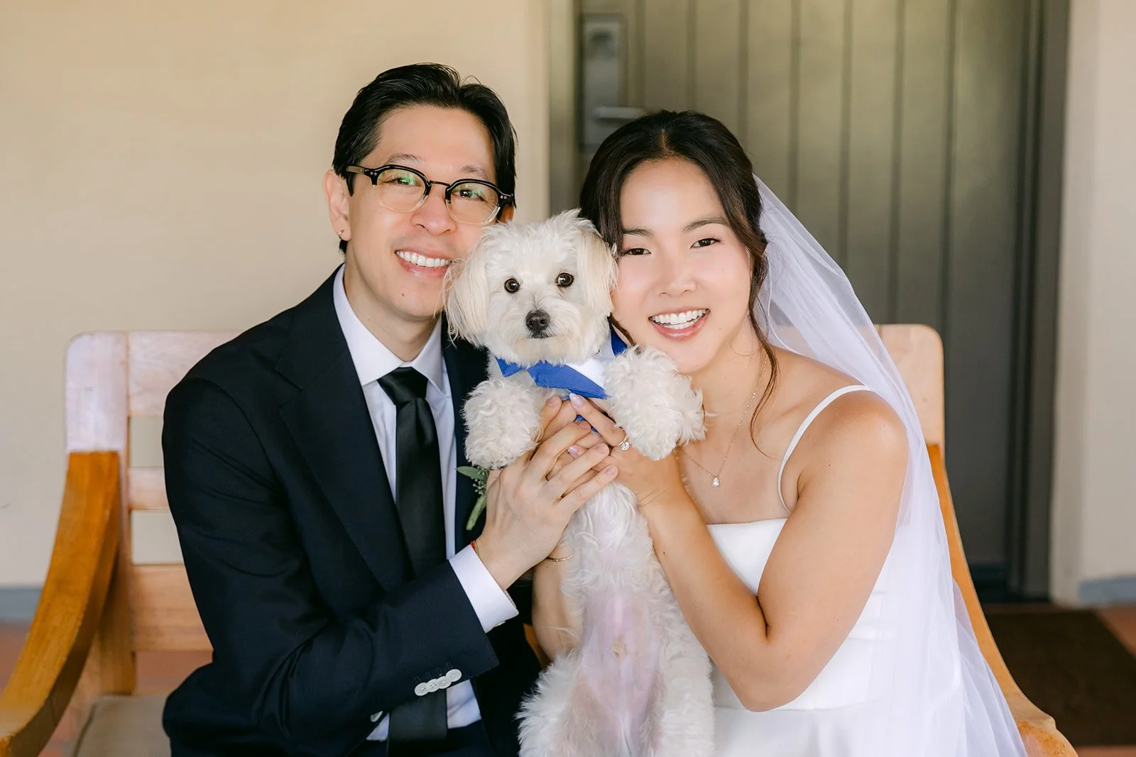 Saya and Leroy posing with their pup after the ceremony