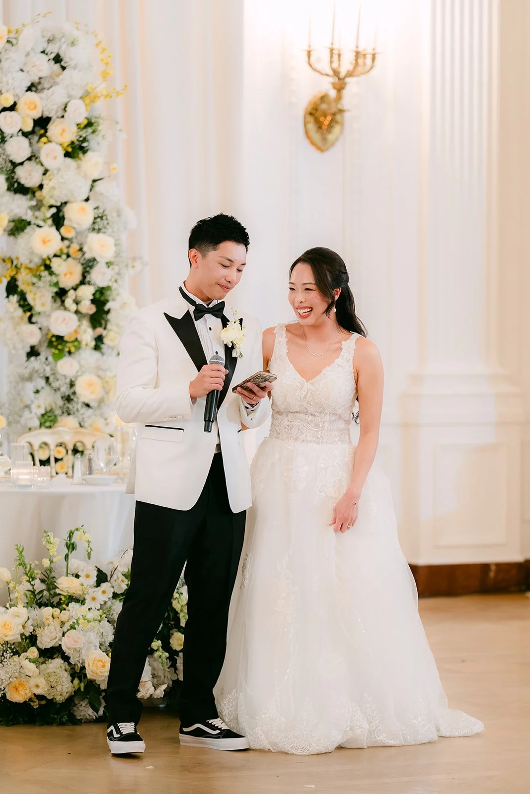 Jenny and Ryan giving a speech in front of the floral arch.