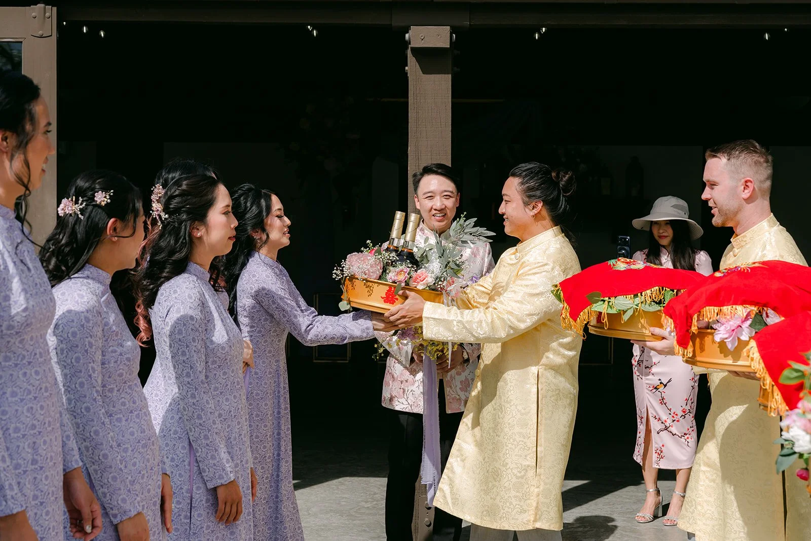 The two families exchanging red gift trays during the procession.