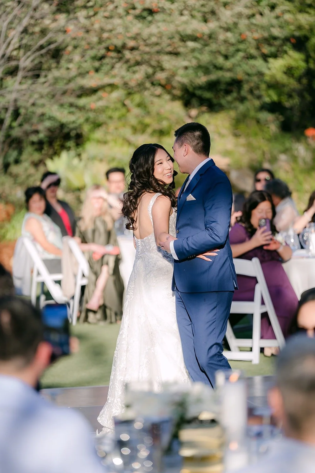 Kelli and Alex dancing as guests watch from their tables