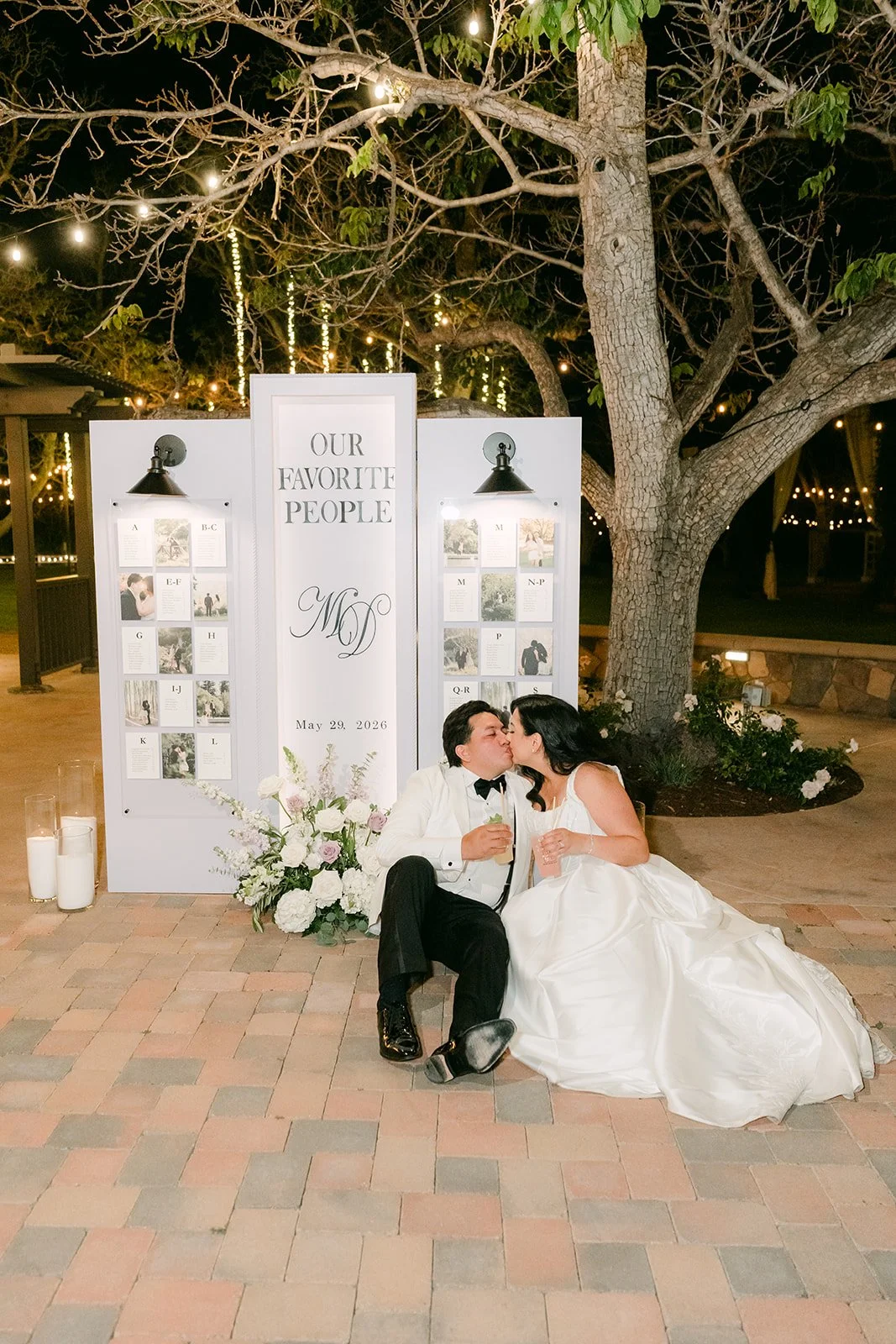 Groom kissing the bride by the Our Favorite People display