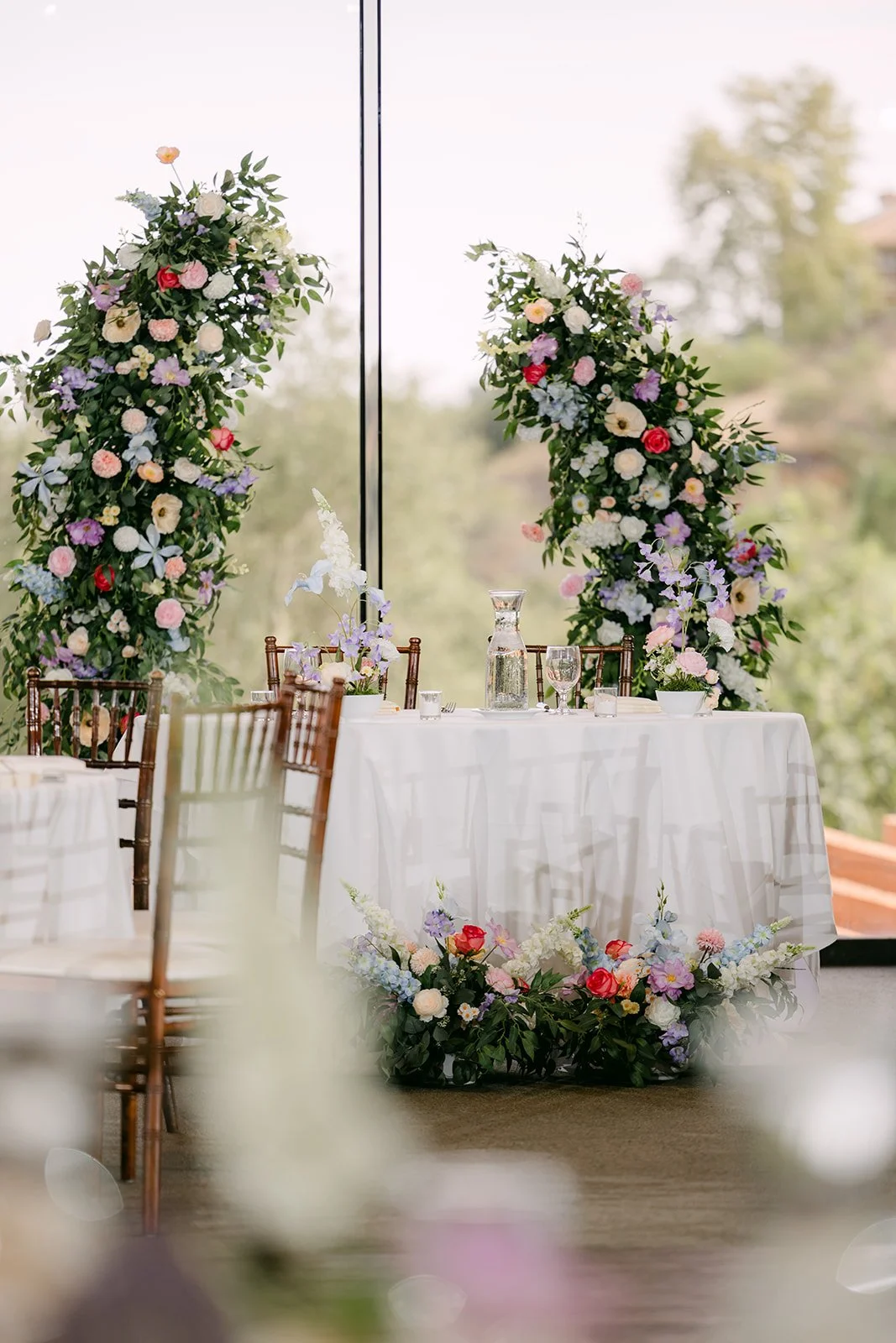The sweetheart table between floral columns