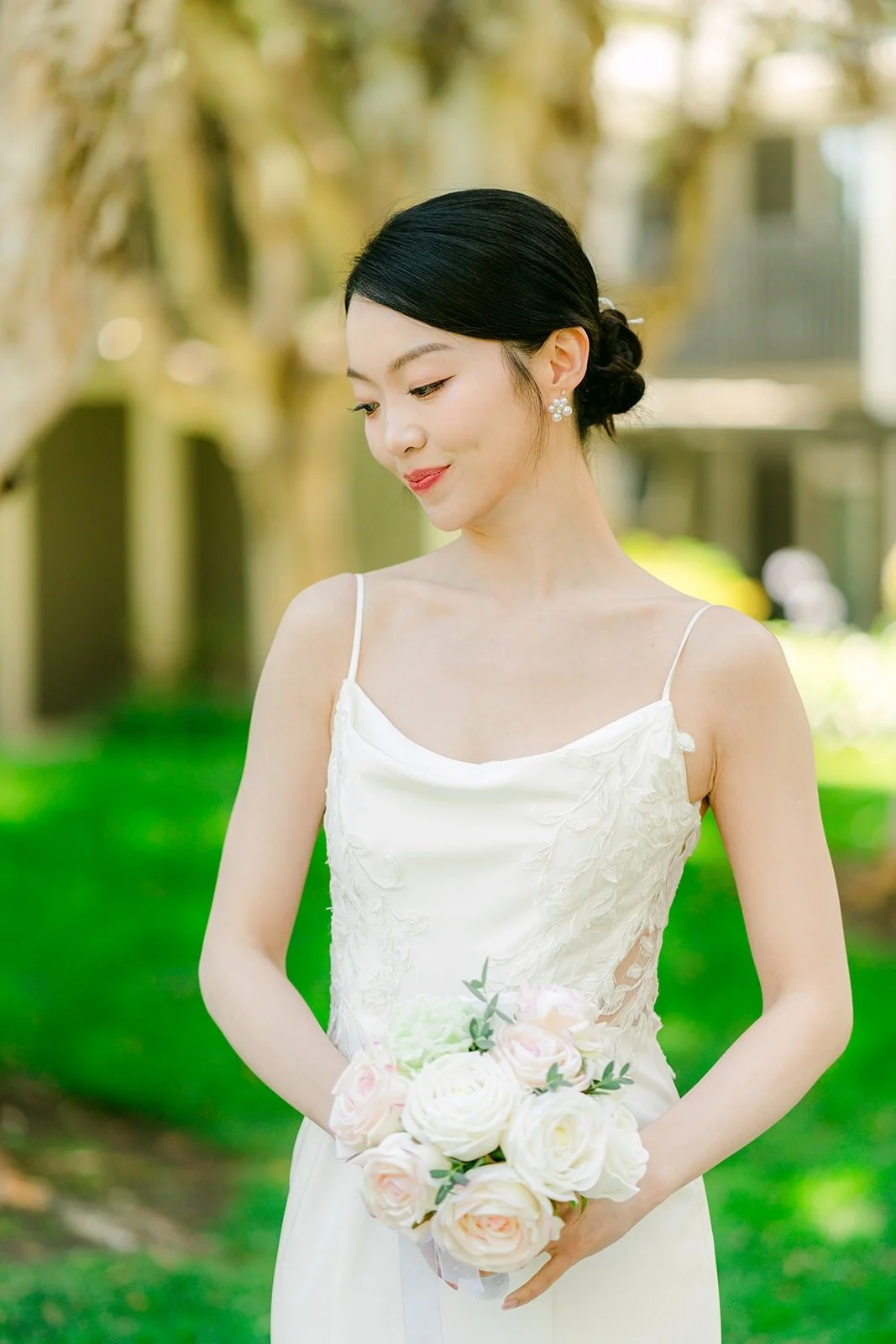 Tin holding her white bouquet in the garden