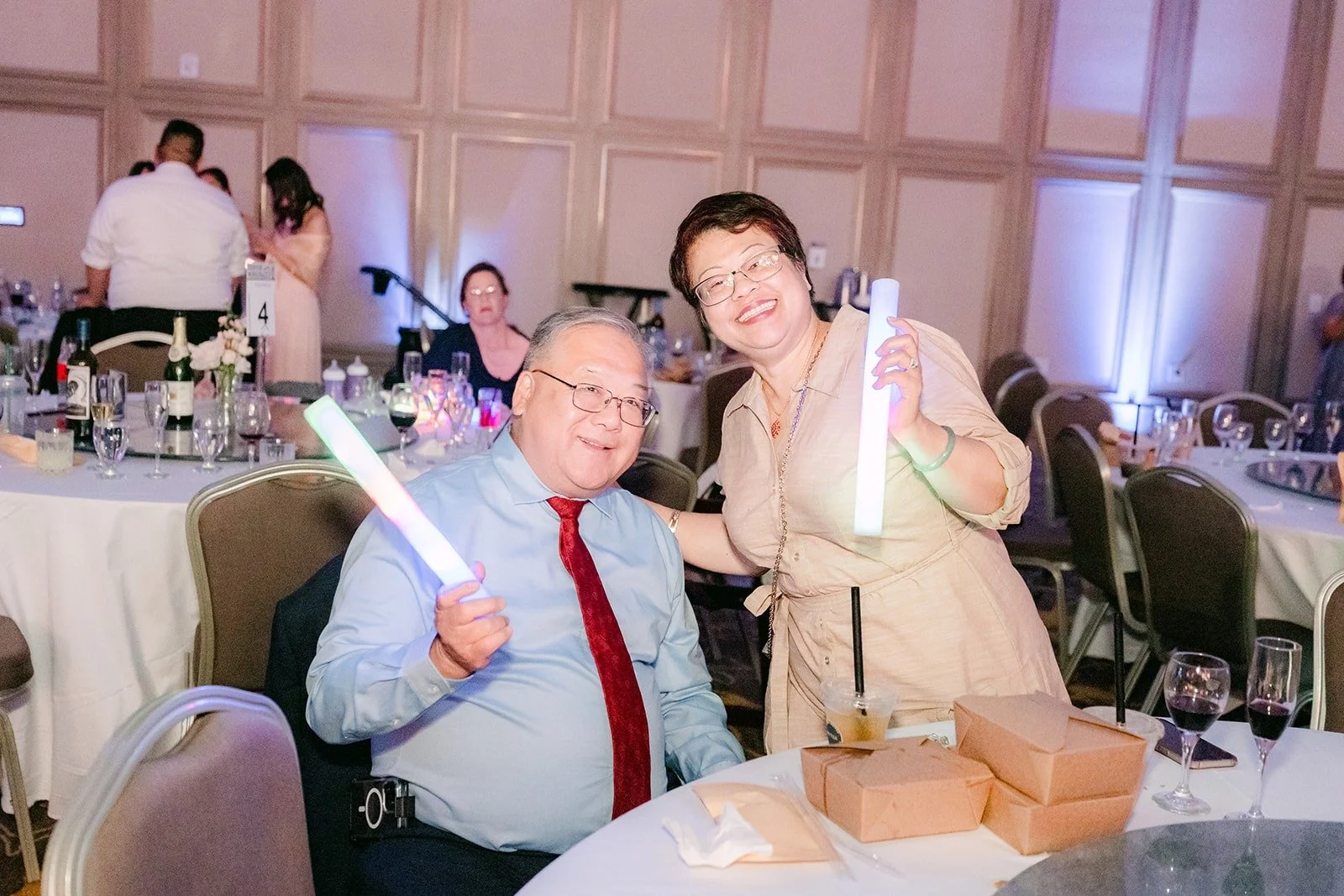 Two guests waving glow sticks from their table