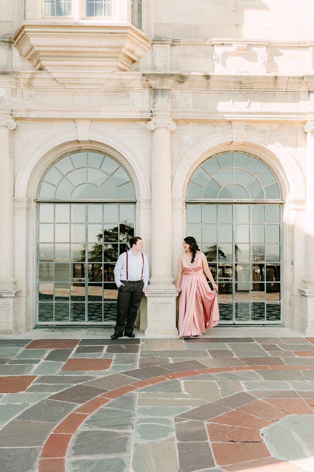 Saira and Matthew before the arched windows on the patterned terrace at Greystone Mansion, photographed by One and Only Production.