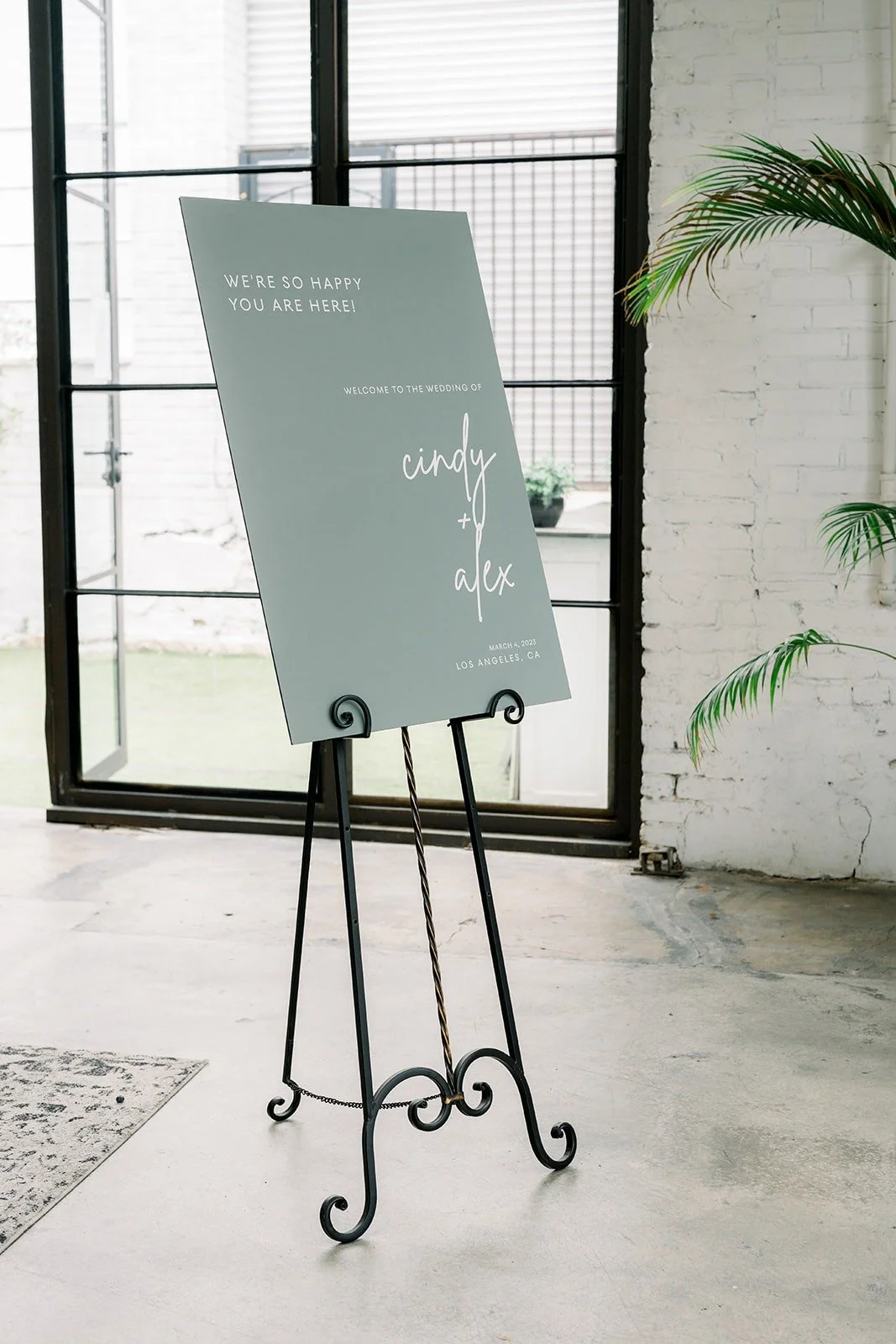 Sage green welcome sign on an easel at The East Angel