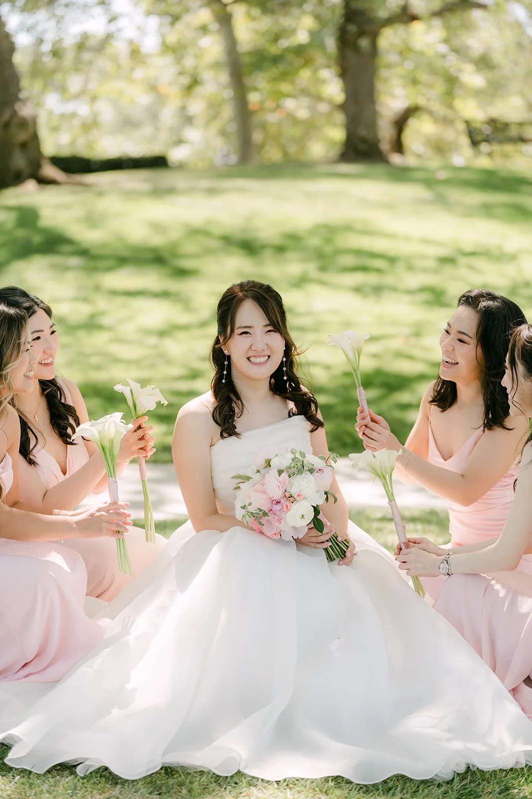Judy seated on the grass with her bridesmaids