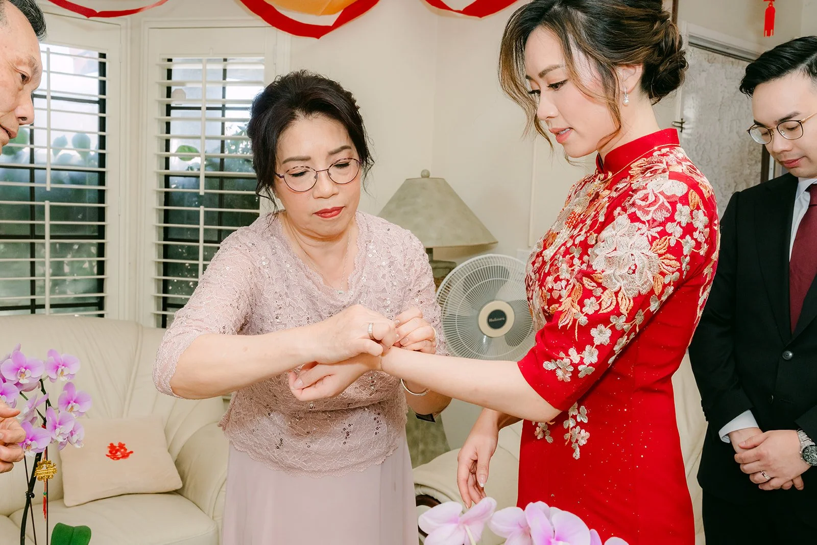 A relative putting a bracelet on Pauline.