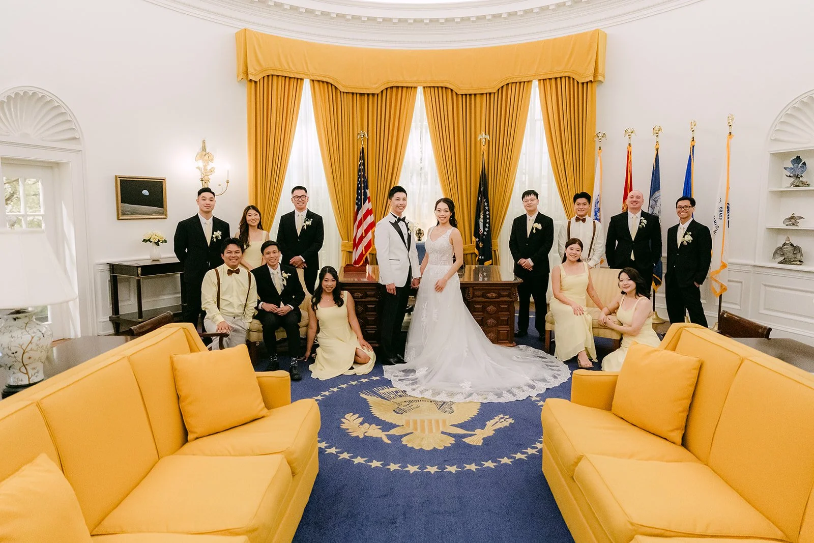 Jenny and Ryan's wedding party in the Oval Office replica with its yellow sofas and presidential seal rug.