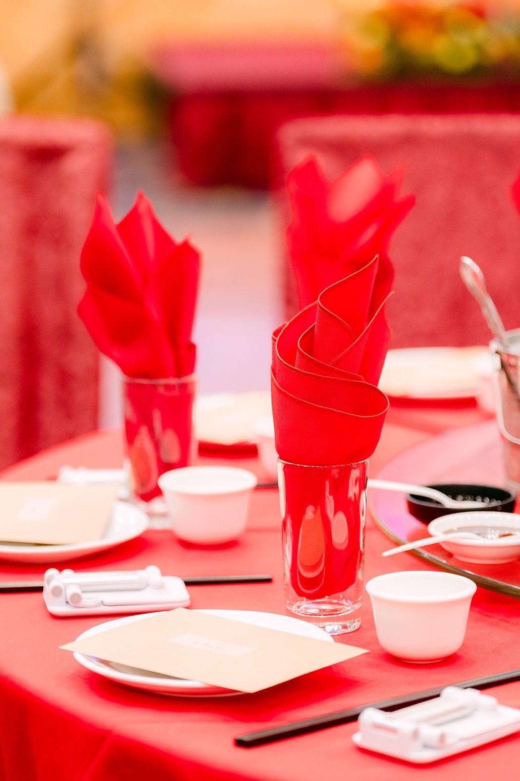 Red napkins folded into glasses on a red tablecloth