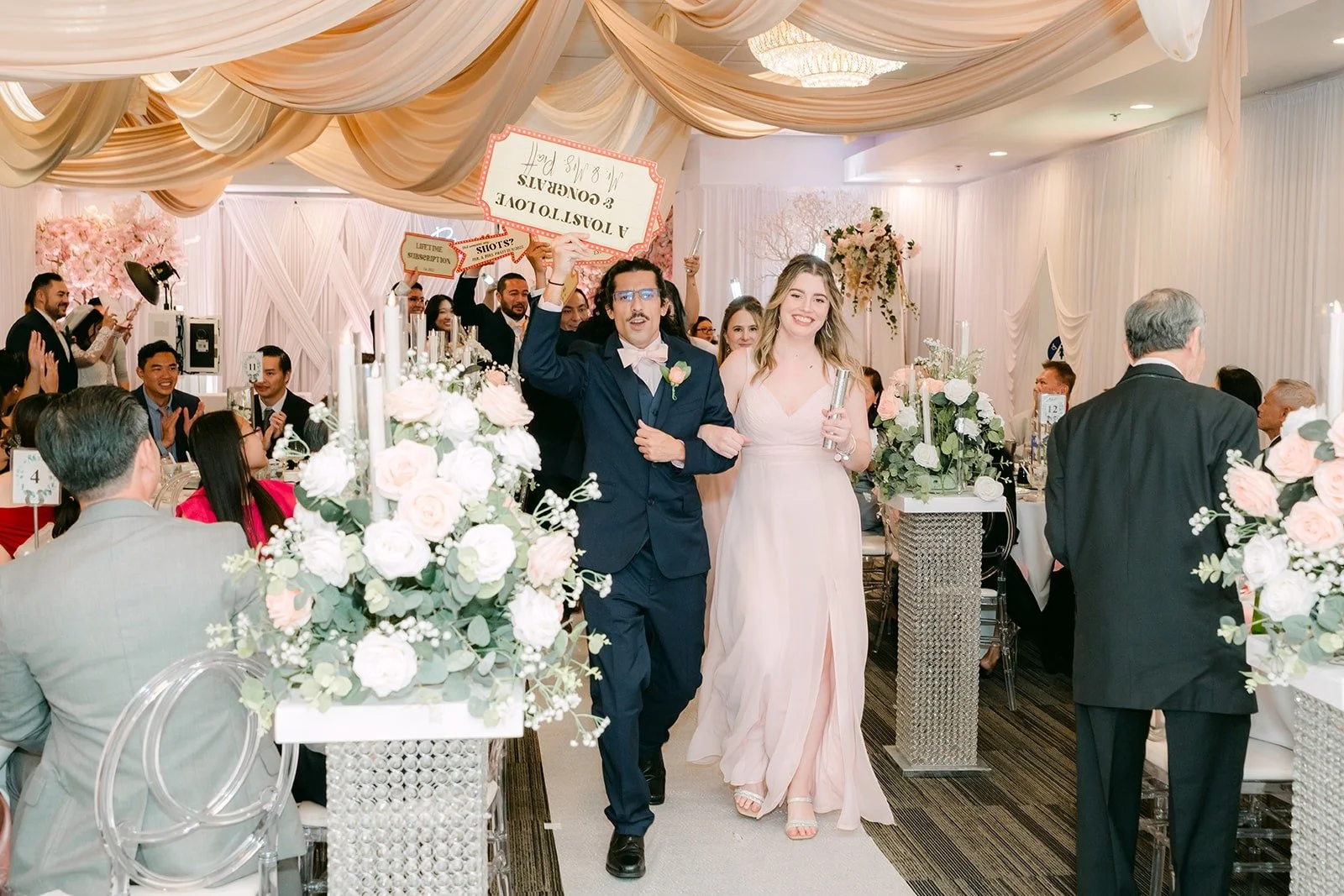 Groomsmen and bridesmaids dancing in with signs during the grand entrance