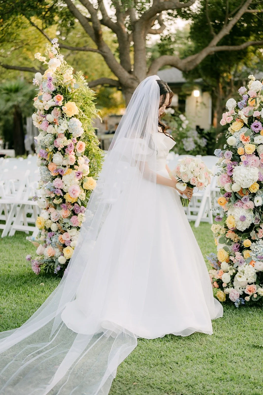 Jeannie's veil and train spread across the grass at the ceremony site