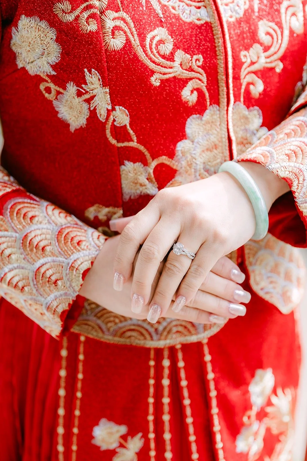 Close up of Sochi's hands and ring against her gold embroidered sleeves