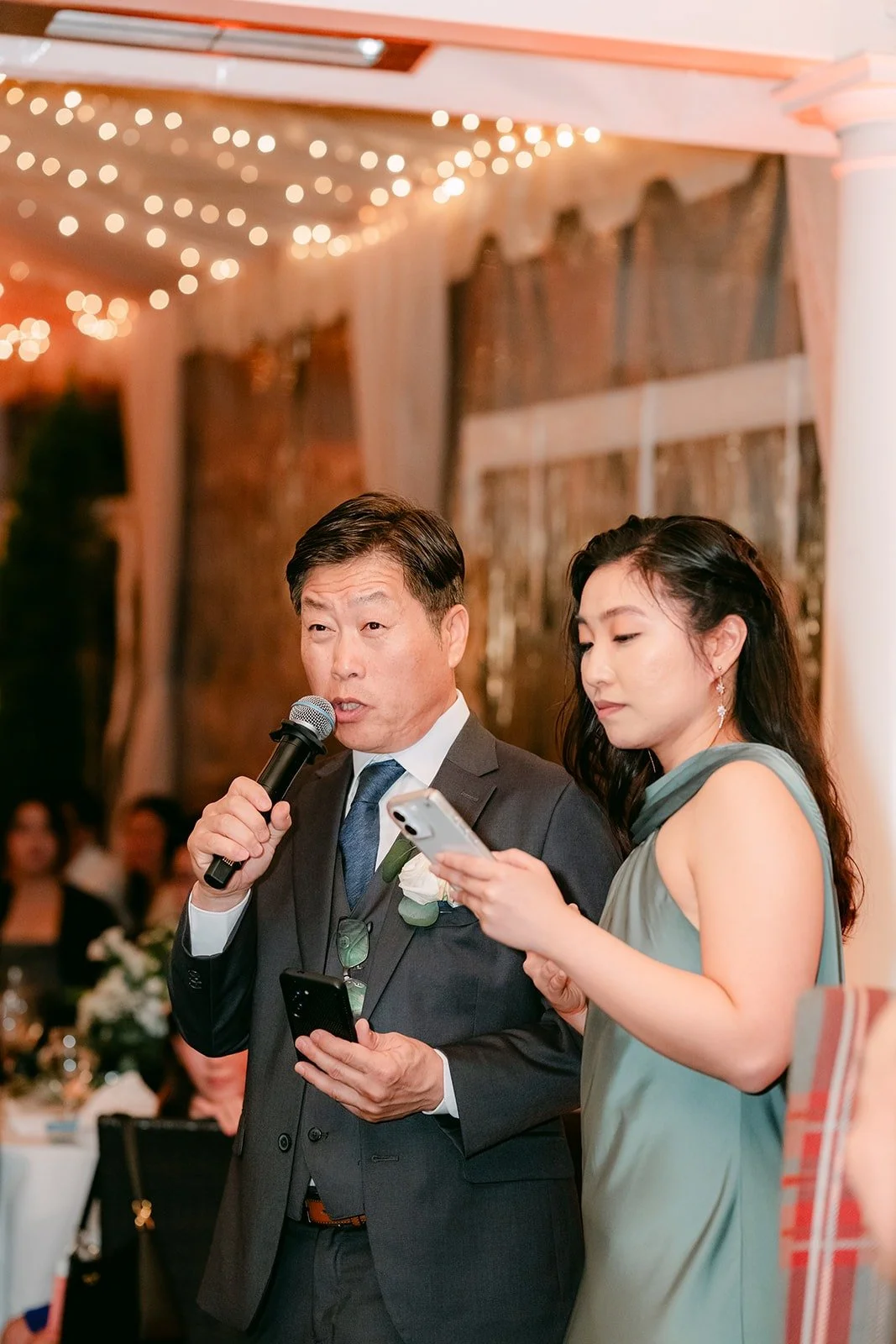A guest giving a toast with a bridesmaid at his side