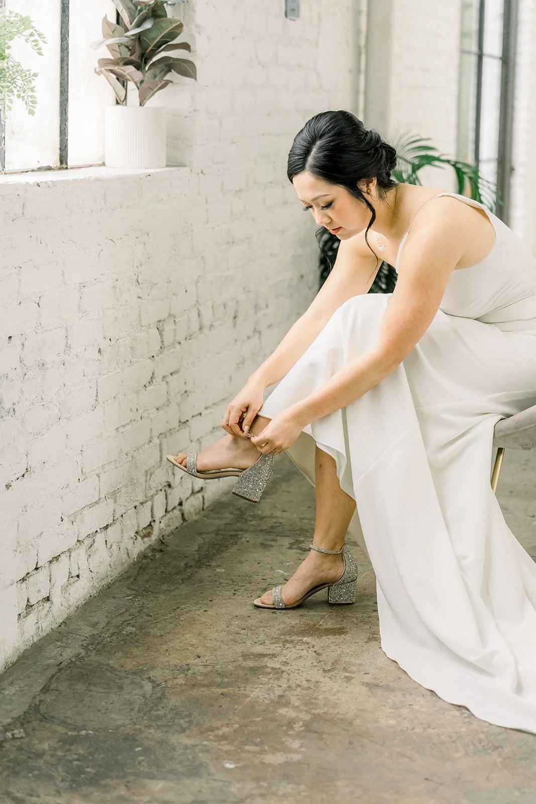Cindy fastens her heels by the window