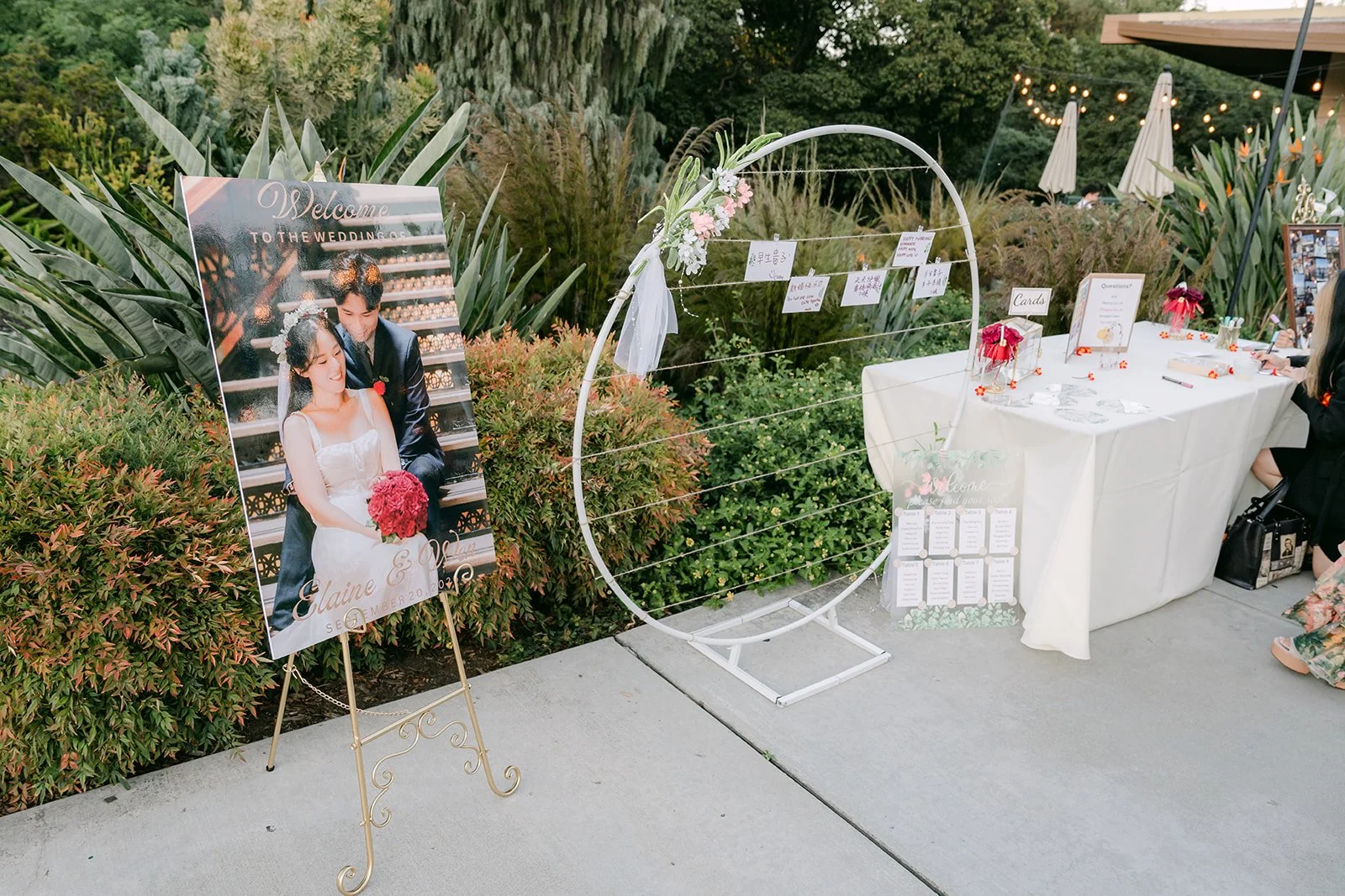 Welcome sign and polaroid guestbook station with a white arch.