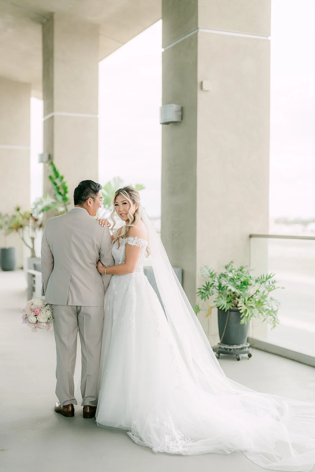Couple embracing between the columns of The Modern's balcony