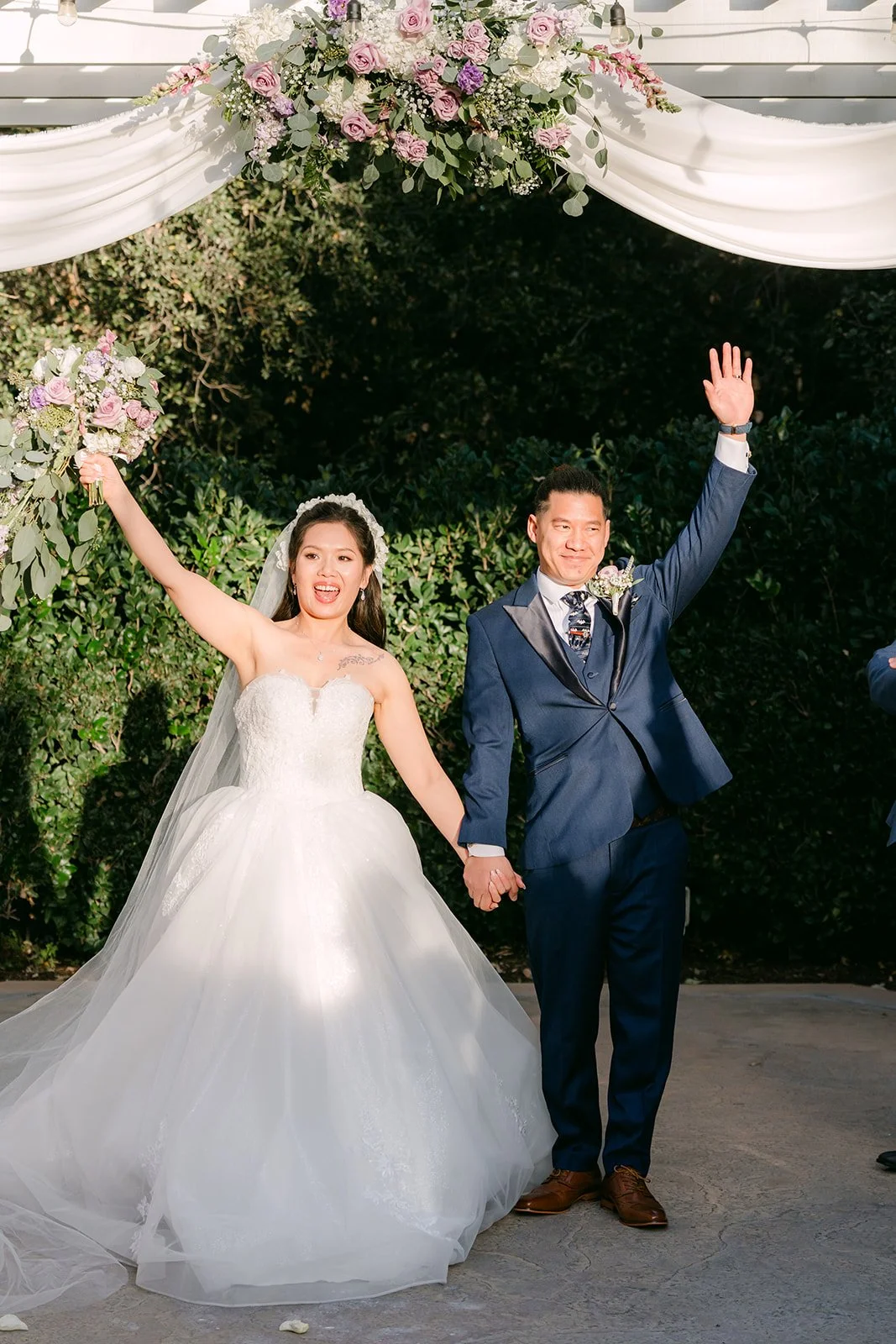 Kate and Michael raising their arms after being pronounced married.