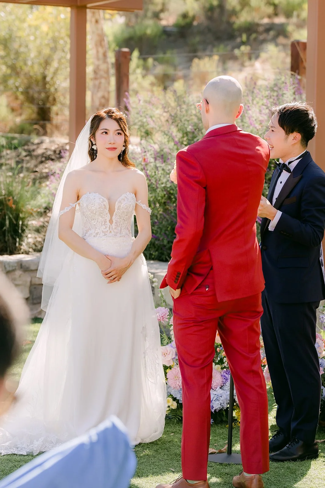 Christie and Christian standing at the front of the ceremony under the pergola.