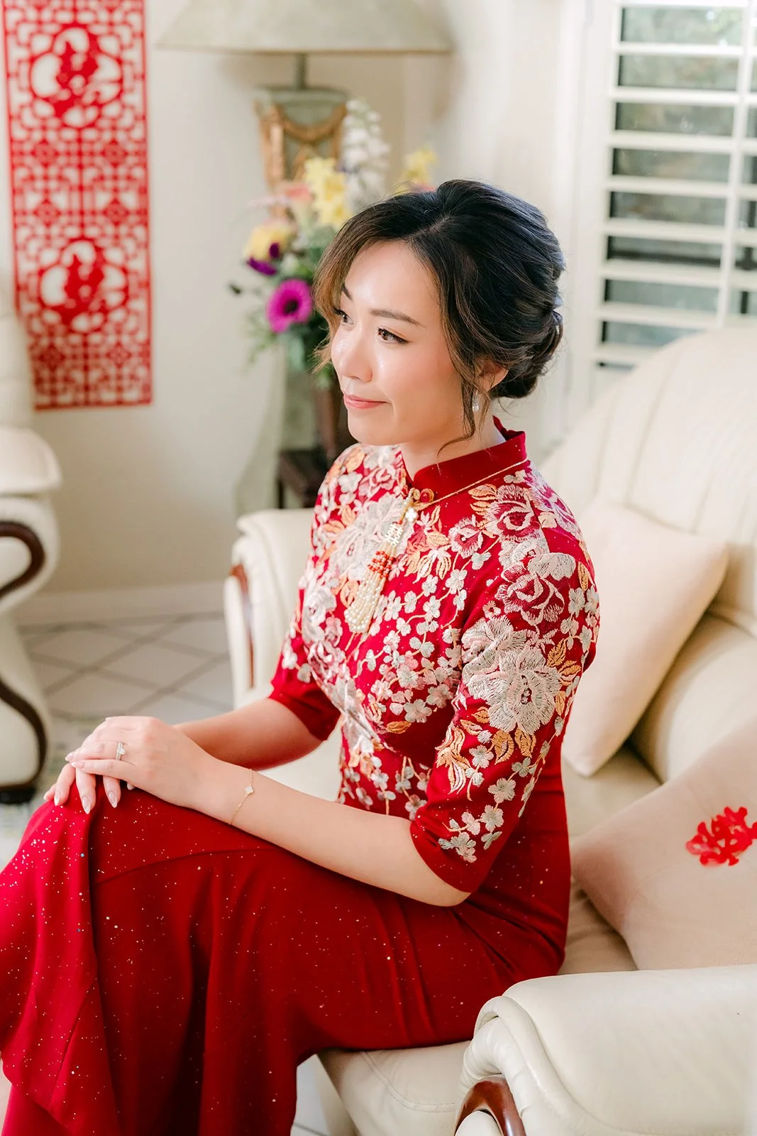 Pauline sitting on the sofa in her qipao, photographed by One and Only Production.