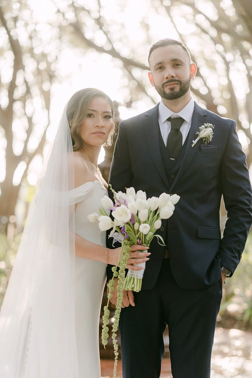 Mariana and Danny standing together with her calla lily bouquet