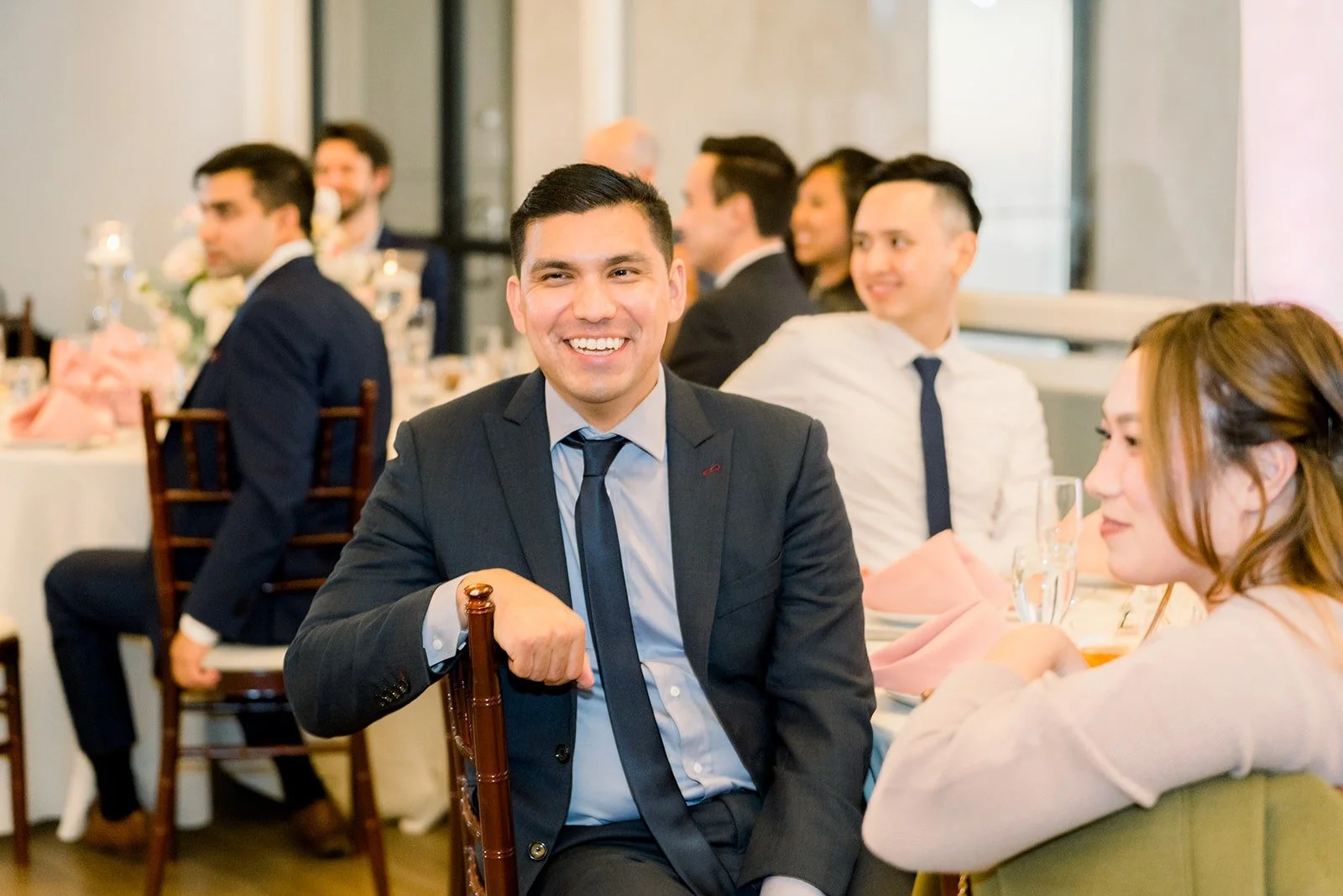 Guests laughing at their tables as the reception begins