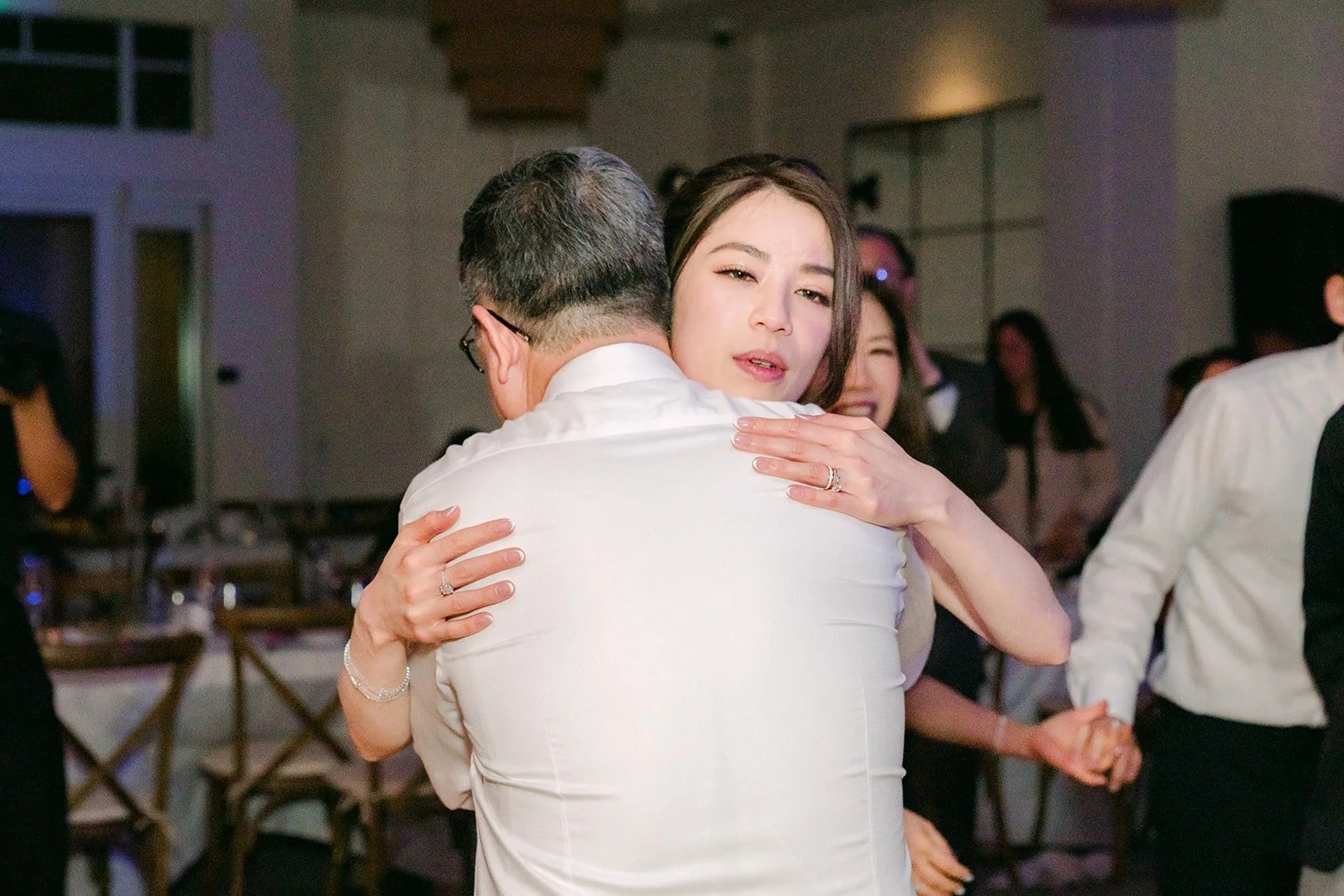 Angela getting a big hug from a guest on the dance floor, photographed by One and Only Production