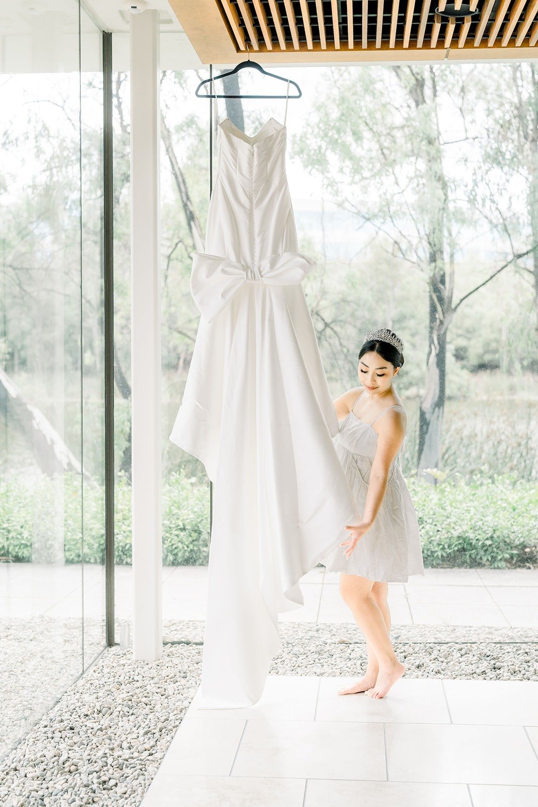 Jacinda's gown hangs by the window as she looks on