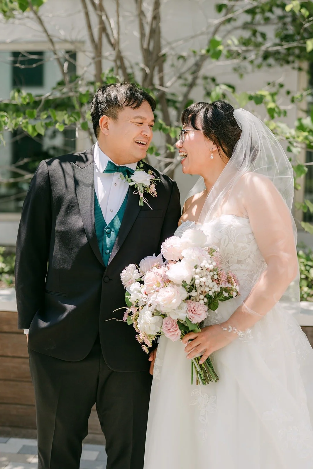 Stella resting her bouquet against James as they lean in close