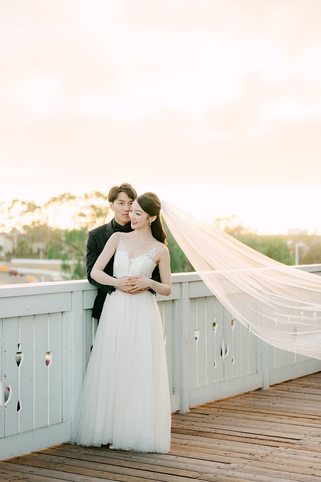 Tin and Fong at the terrace railing with the sun going down