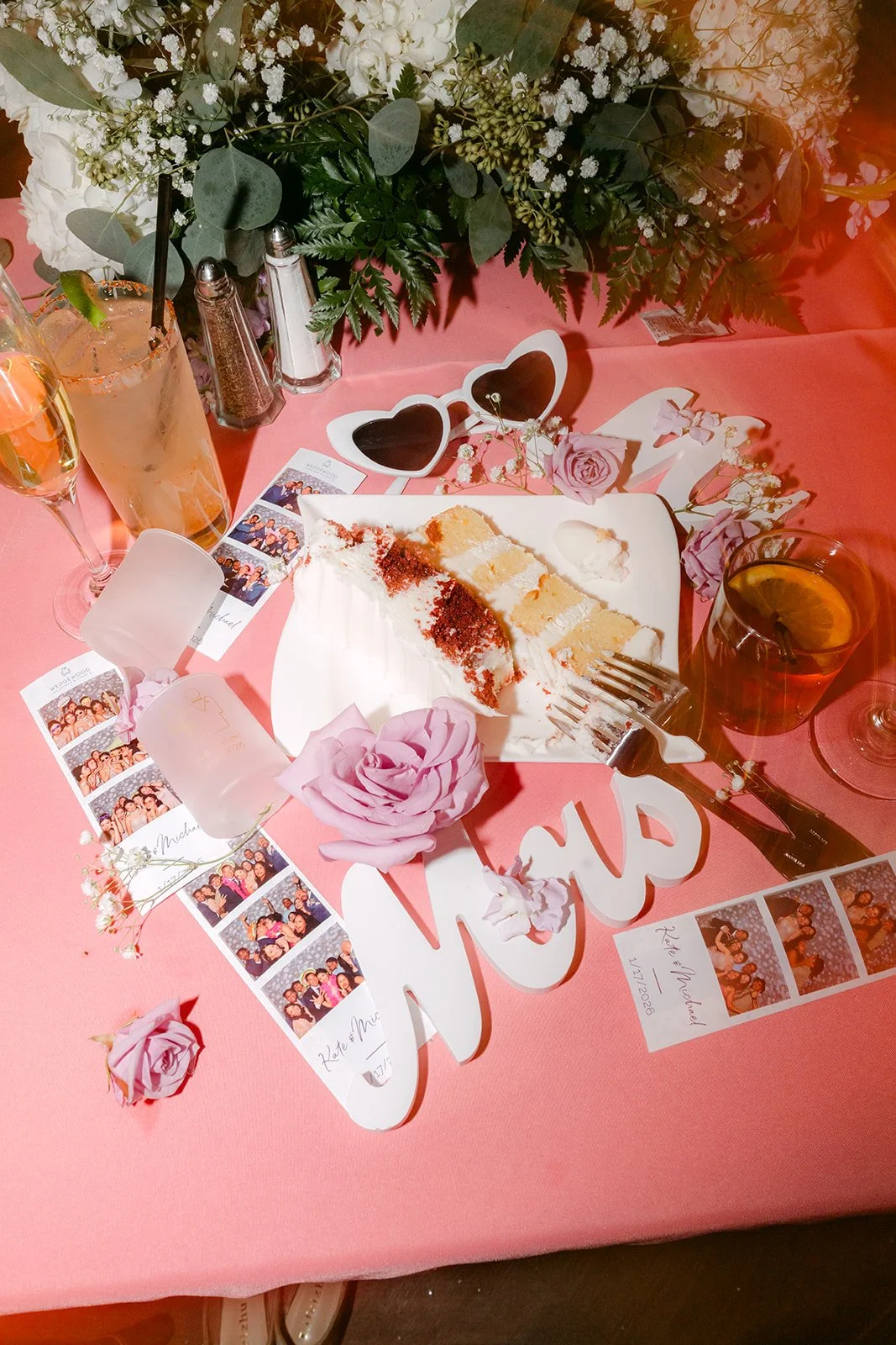 Wedding favors on a pink table at the reception, photographed by One and Only Production.