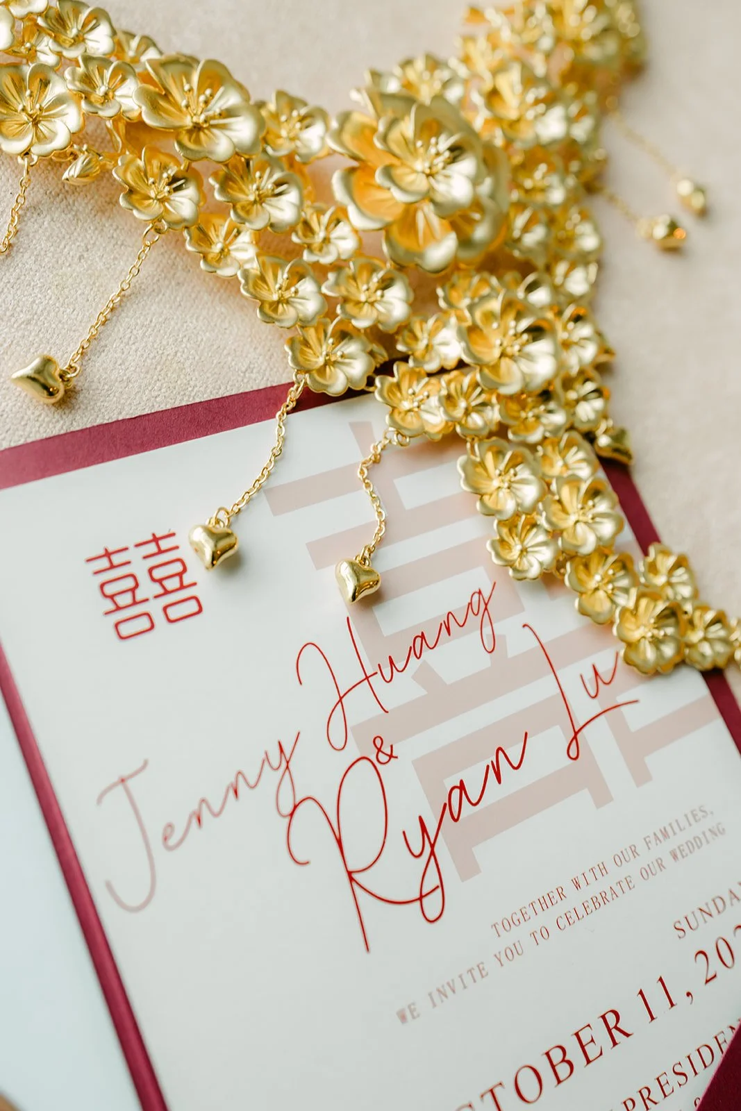 An elaborate gold necklace resting on the couple's wedding invitation.
