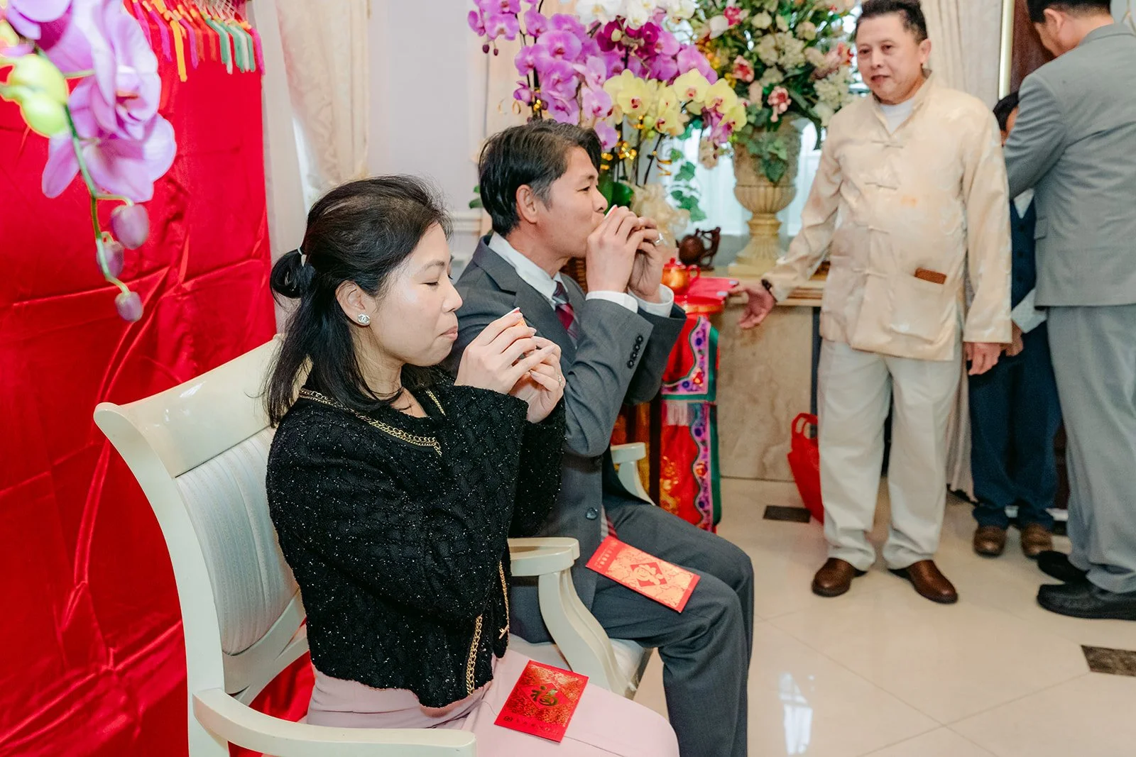 A bride and groom serving tea to an aunt and uncle in the living room.
