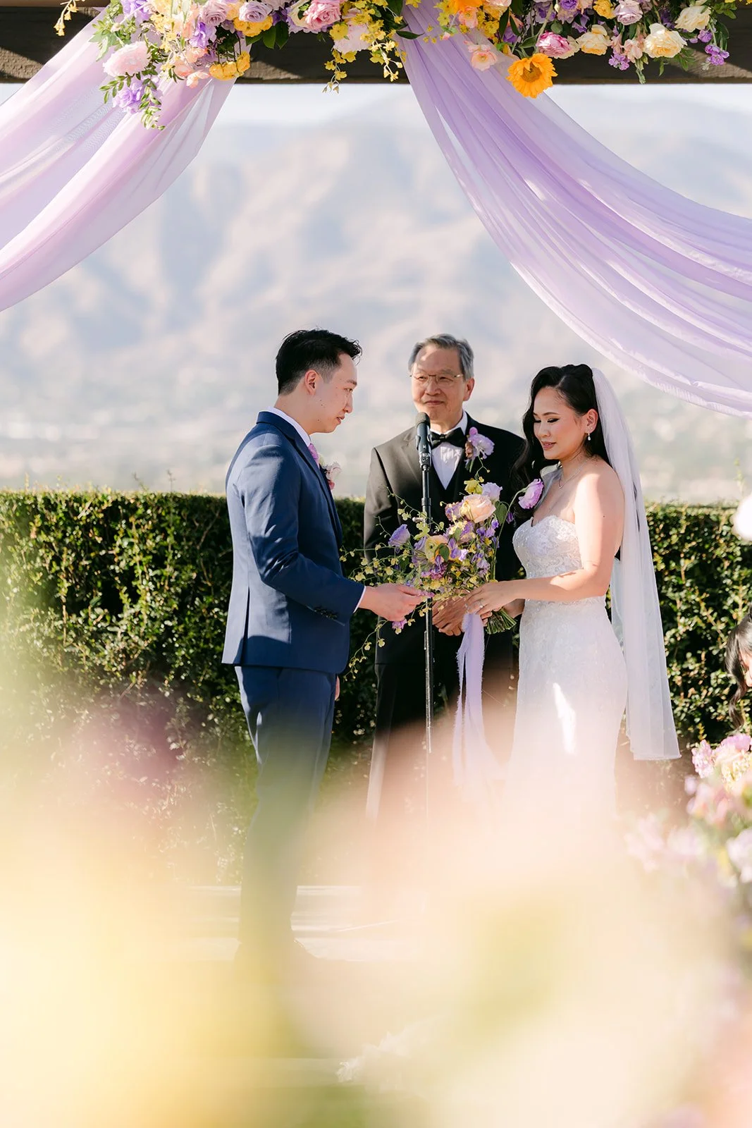 Vannie and Elijah under the lilac draping at the altar.
