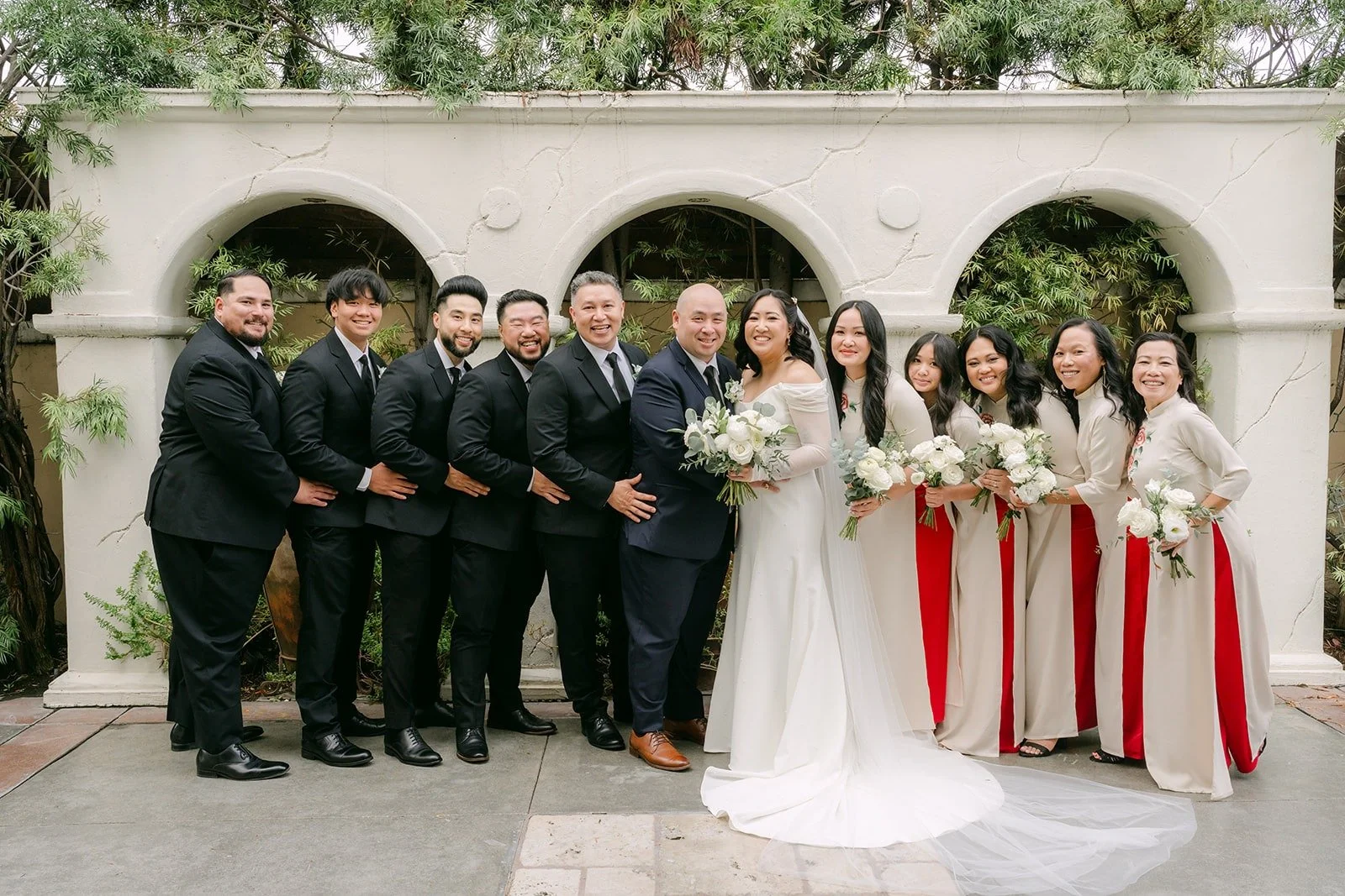 Full wedding party under the arches at The Villa