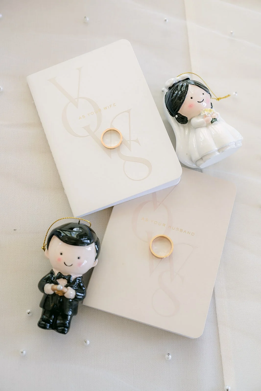 Rings beside tiny bride and groom figurines