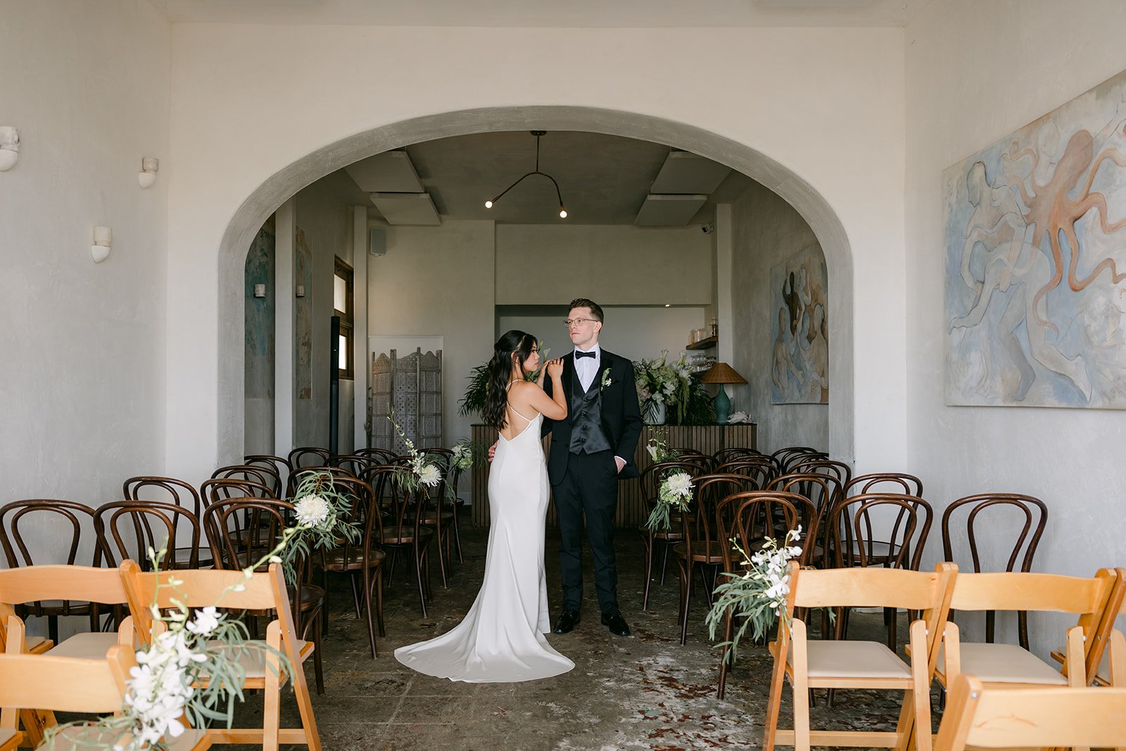 A wide portrait of the couple under the arch at Fig Tree Venice