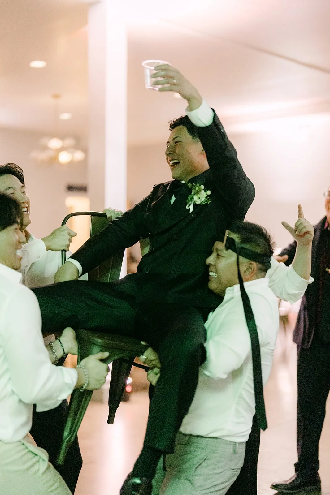Groomsman lifted above the crowd on the dance floor