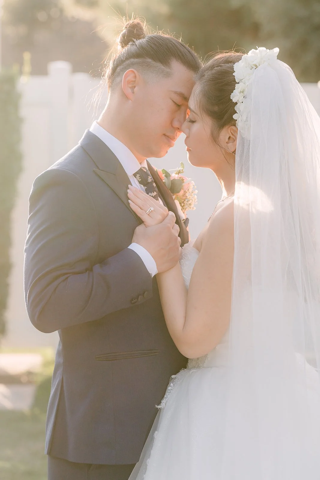 Michael and Kate touching foreheads in soft light.
