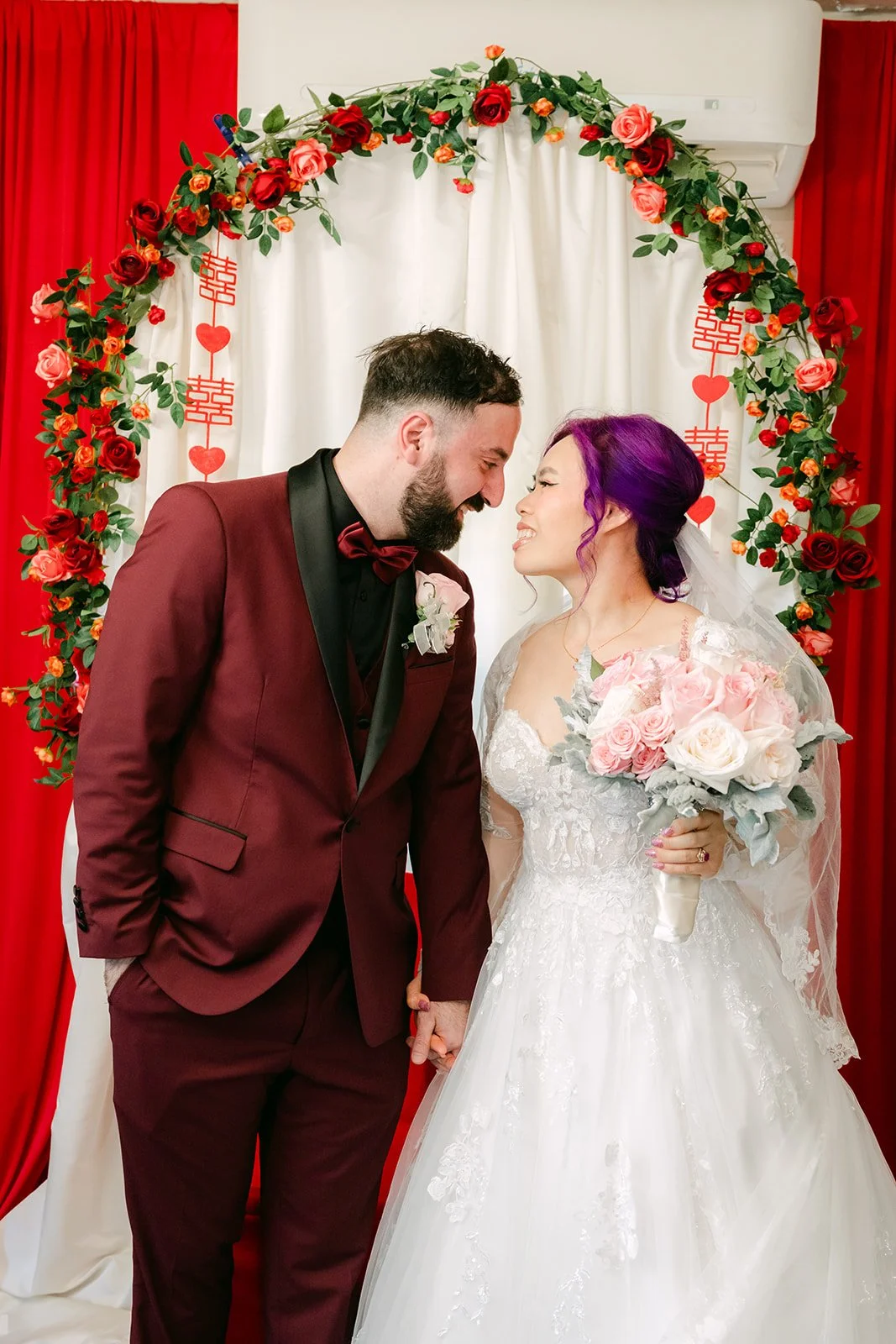 Ryan kissing Vanessa's forehead under the rose arch.
