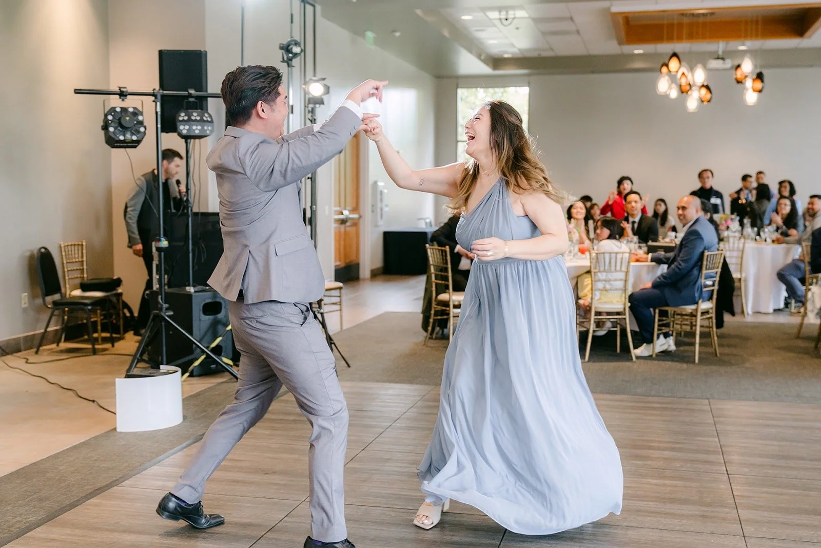 A groomsman and bridesmaid showing off their moves at the entrance