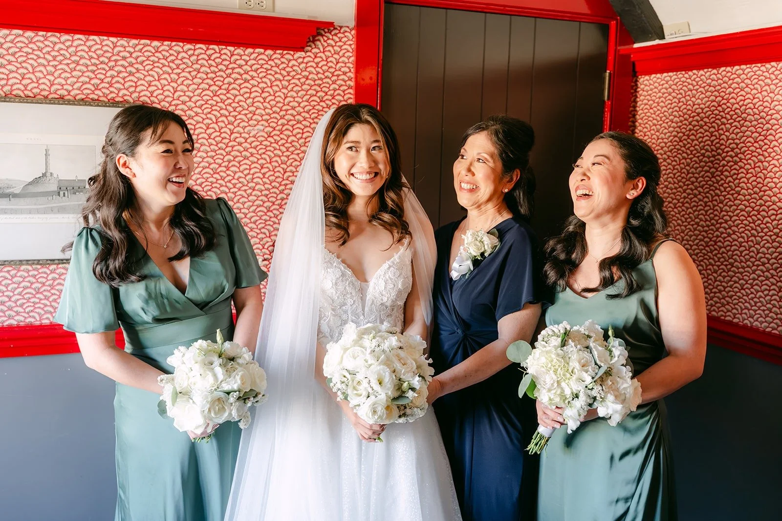 Valerie laughing with her bridesmaids in sage green dresses