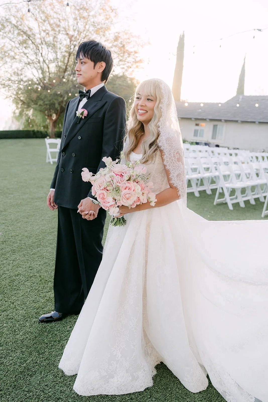 Konitha and Job standing together on the lawn after the ceremony