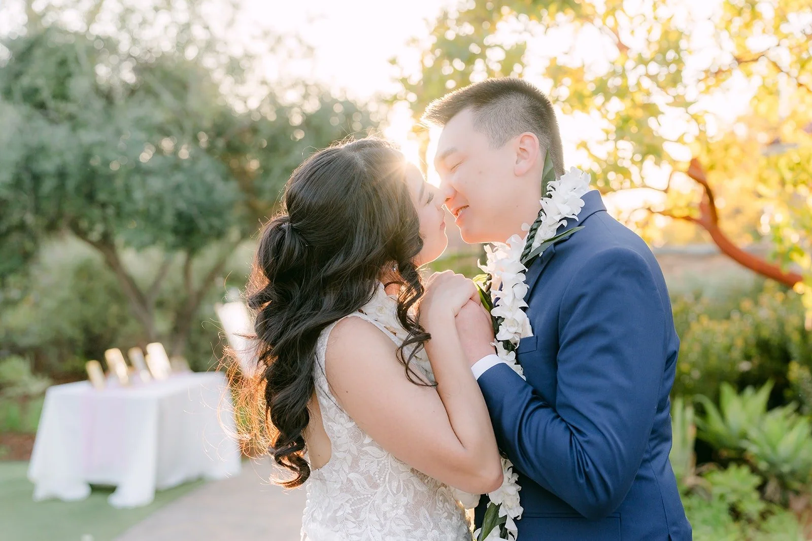 Kelli and Alex sharing a kiss in the golden hour light at Los Robles Greens